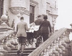 an old black and white photo of people on the stairs with a baby in a stroller