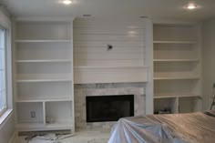 a living room with white bookcases and a fireplace