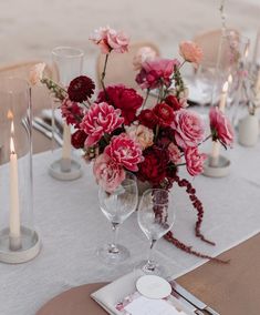 a table set with flowers and candles for an elegant wedding reception or special event in red, pink and white colors