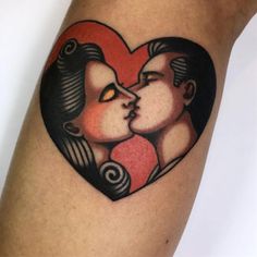 a couple kissing in the shape of a heart tattoo on someone's leg,