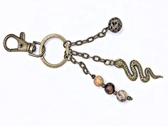 a keychain with two charms attached to it's sides and a snake on the end