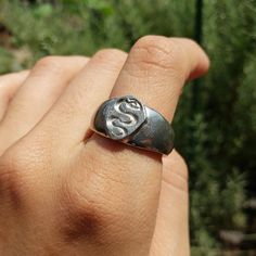 a person wearing a ring with the letter s on it