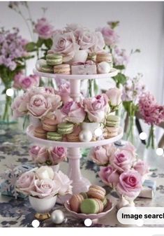 three tiered cake stand with pink flowers and macaroons