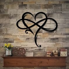 a fireplace with a heart shaped iron decoration on it's mantle next to a brick wall