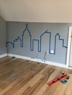 a room that has been painted with blue paint and tools on the floor, along with construction tape