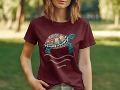 Dive into summer with this vibrant, boho-chic sea turtle t-shirt. The colorful tortoise illustration brings a playful touch to your beach wardrobe, while the comfortable fit makes it perfect for everyday wear. Enjoy the ease of a unisex design that suits everyone and celebrate ocean life with this unique graphic tee. It's an ideal gift for sea creature lovers or a special treat for yourself that adds a splash of artistry to your casual look.Product Features:Fabrication: 100% Airlume combed and r Multicolor Bohemian T-shirt For Beach, Multicolor Bohemian T-shirt For The Beach, Bohemian Multicolor T-shirt For Beach, Tortoise Illustration, Beach Wardrobe, Sea Creature, Ocean Life, Staple Pieces, Casual Shirt