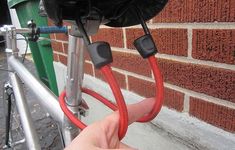 someone is holding the handlebars on their bike and pointing at it in front of a brick wall