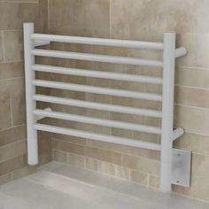 a white towel rack in the corner of a tiled bathroom with beige tiles on the wall