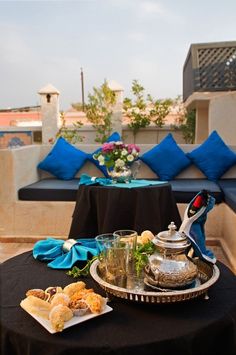 a tray with food on top of a table next to blue pillows and some flowers