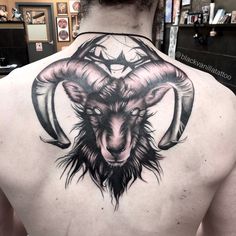 the back of a man's upper body with an animal head tattoo on it