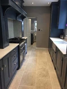 a large kitchen with blue cabinets and white counter tops is pictured in this image from the front view