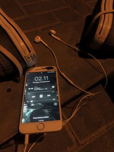 an iphone is hooked up to headphones on the ground