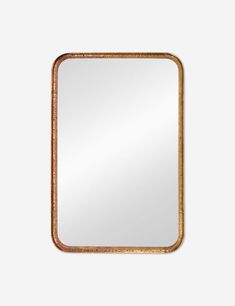 a gold framed mirror on a white wall with an aged wood frame and metal trim