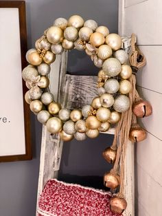 a wreath is hanging on the wall next to a red and white pillow with ornaments