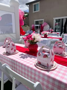 a table set up for a party with pink and white decorations on top of it