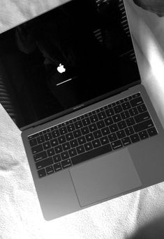 an open laptop computer sitting on top of a bed