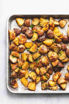 roasted potatoes with herbs on a baking sheet