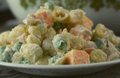 a white bowl filled with pasta salad on top of a table