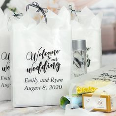 three bags with wedding favors on them sitting next to each other