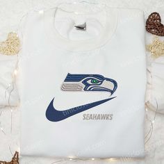 Seattle Seahawks x Nike Swoosh Embroidered Shirt, NFL Sports Embroidered Hoodie, Best Gift Idea Sports Long Sleeve Hoodie With Embroidery, Sporty Embroidered Sweatshirt For Sports Season, Sporty College Hoodie With Custom Embroidery, Sports Hooded Top With Embroidered Logo, Sporty Fleece Hoodie With Embroidered Graphics, White Embroidered Logo Athletic Sweatshirt, Sporty Embroidered Fleece Hoodie, Sporty Embroidered Fleece Sweatshirt, Embroidered Crew Neck Sports Hoodie