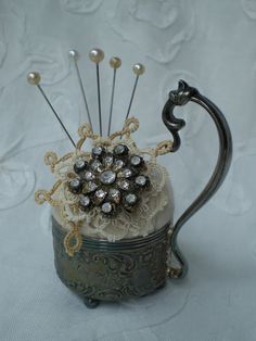 a tea pot with some pins in it