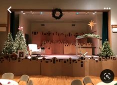 the stage is decorated with cardboard boxes and christmas trees