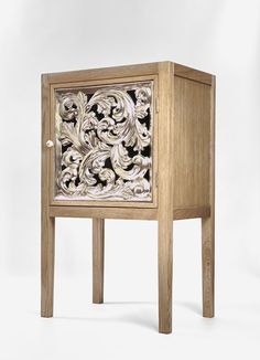 a wooden cabinet with an intricate design on the front and side panels, sitting against a white background