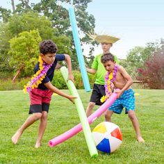 three young boys playing with beach balls and inflatable tubes