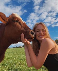 a woman is posing for a photo with a cow