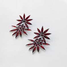 Add a touch of glamour to your look with these gorgeous double star design drop earrings. These earrings are designed in a ruby red colourway using glass gemstones and set in black metal, making them comfortable, lightweight, and easy to wear from day to night. Perfect to get statement compliments with any outfit or occasion. Premium Quality: The lightweight material gives them a more delicate feel than solid metal, making them a great option for days when you want to look stylish both casual and formal attire. Perfect Gift: These round earrings are suitable for various occasions, such as birthday parties, weddings, feasts, engagements, anniversaries, festival celebrations, and so on. Great gift for your girlfriend, wife, mum, daughter, and friend. SPECS: ✔︎ Material: Glass Crystal Set in Red Flower Shape Earrings For Party, Red Floral Earrings For Party, Red Flower Shaped Party Earrings, Elegant Red Crystal Earrings, Red Star-shaped Party Jewelry, Festive Red Dangle Crystal Earrings, Red Star-shaped Jewelry For Parties, Glamorous Red Crystal Earrings, Red Flower-shaped Earrings For Party