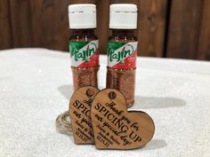 two small wooden tags sitting on top of a table next to bottles of spa shaving up