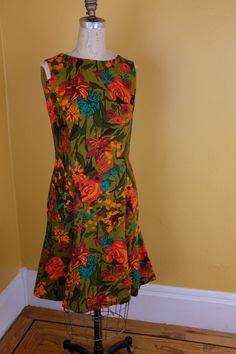 "Flirt, vivid 60s/70s dress made of a medium weight cotton or cotton blend. The green is kind of mustardy. Princess seams front and back, lap zipper (metal). Though the waist measures 29-30\" on a hanger, the dress fits nicely on the form in the photo, which has a 26 1/2 waist measurement." Black Velvet Gown, Floral Cotton Dress, Velvet Gown, 70s Dress, Princess Seam, Silk Velvet, Cotton Dresses, Dress Making, High Neck Dress