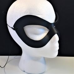 a white mannequin head with a black mask on it