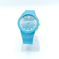 Authentic Swatch ACID DROP Chrono Plastic (SUSL400) Watch. The Swatch Chrono Plastic ACID DROP is from the dynamic Sports Collection. On the turquoise dial are yellow numbers and turquoise and white hands indicate the time. The beautiful chronograph has a date display at the 3 o'clock position. A plastic case and soft silicone strap, all in turquoise with yellow accents, completes the design. The waterproof watch is driven by an accurate quartz movement with a battery. Everyone knows a Swatch wh Green Sports Watch With Round Dial, Casual Blue Watch With Stopwatch, Green Casual Sports Watch, Modern Blue Digital Watch With Round Dial, Casual Green Watch With 10atm Water Resistance, Blue Sports Watches With Analog Display, Blue Analog Sports Watch, Blue Casual Analog Watch Accessories, Casual Blue Watch Accessories With Round Dial