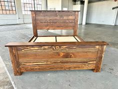 a wooden bed frame sitting on top of cement