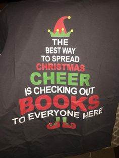 a black t - shirt with the words, best way to spread christmas cheer is checking out books to everyone here