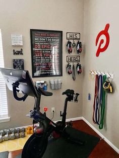 there is a stationary bike in the corner of this room with many sports memorabilia on the wall