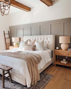 a bedroom with a bed, nightstands and two lamps on either side of the bed