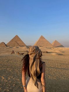 a woman standing in front of three pyramids