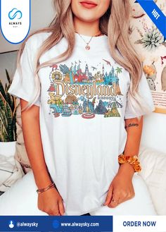 a woman with long blonde hair wearing a white disneyland t - shirt and holding her hands in her pockets