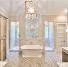 a large bathroom with marble walls and flooring is pictured in this image, it has a chandelier hanging from the ceiling