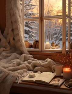 an open book sitting on top of a window sill next to a cup and saucer