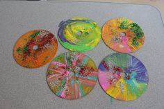 four cds with different colors and designs on them sitting on top of a white table