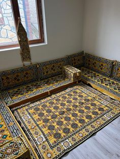 an ornately decorated couch in front of a stained glass window with a wooden box on it