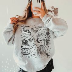 This Halloween Shirt has a retro vibe with fun spooky season graphics. You will want to wear this cute Fall shirt on repeat.  This is a relaxed fit unisex sweatshirt, but true to size. We recommend sizing up if you want a trendy oversized look. - M A T E R I A L S - Gildan® Sweatshirt 8 oz./yd² (US) 50/50 cotton/polyester Heather Sport colors: 60/40 polyester/cotton Loose Fit Ribbed Knit Collar to retain shape - C A R E  I N S T R U C T I O N S - Inside out, wash with delicate cycle Do not iron Spooky Graphic Print Top For Fall, Spooky Graphic Print Tops For Fall, Witchy Tops For Halloween Streetwear, Spooky Skull Print Top For Fall, Witchy Streetwear Tops For Halloween, Spooky Screen Print Tops For Fall, Spooky Fall Tops With Screen Print, Spooky Skull Print Tops For Fall, Cute Tops For Halloween Streetwear