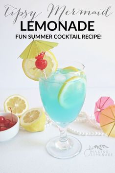 a blue cocktail with lemons and cherries on the rim