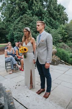 a man and woman standing next to each other in front of people sitting on chairs