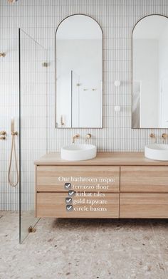 a bathroom with two sinks and mirrors on the wall