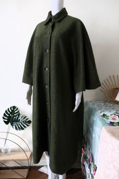 Beautiful Vintage cape from the 1980s. Made from a relatively light mottled green fabric. Classic collar, button front. Generous cut with slightly shortened sleeves. One button on each side, other than that the sides are open. Lined. Looks great with a turtleneck sweater, a pair of jeans and loafers or ankle boots! BRAND: No brand label anymore ERA: 1980s COLOR: Dark green mottled FABRIC: No fabric tag anymore, it's a synthetic blend with a percentage wool; synthetic lining SIZE: No size tag, fits best modern size S to L - please check the measurements below for reference MEASUREMENTS: Free pit to pit, total length without collar 110cm CONDITION: Very good Vintage condition Vintage Green Outerwear With Stand Collar, Oversized Green Cape Outerwear, Green Fall Outerwear With Covered Buttons, Oversized Green Cape For Winter, Oversized Green Cape For Fall, Vintage Cape, Wool Cape, Linen Jacket, Brand Label