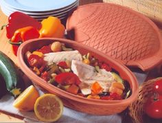 a bowl filled with food sitting on top of a table next to plates and bowls